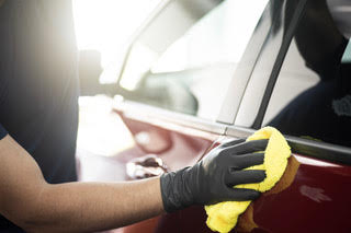 Cleaning the car windows after a wash and wax service in fort worth, texas